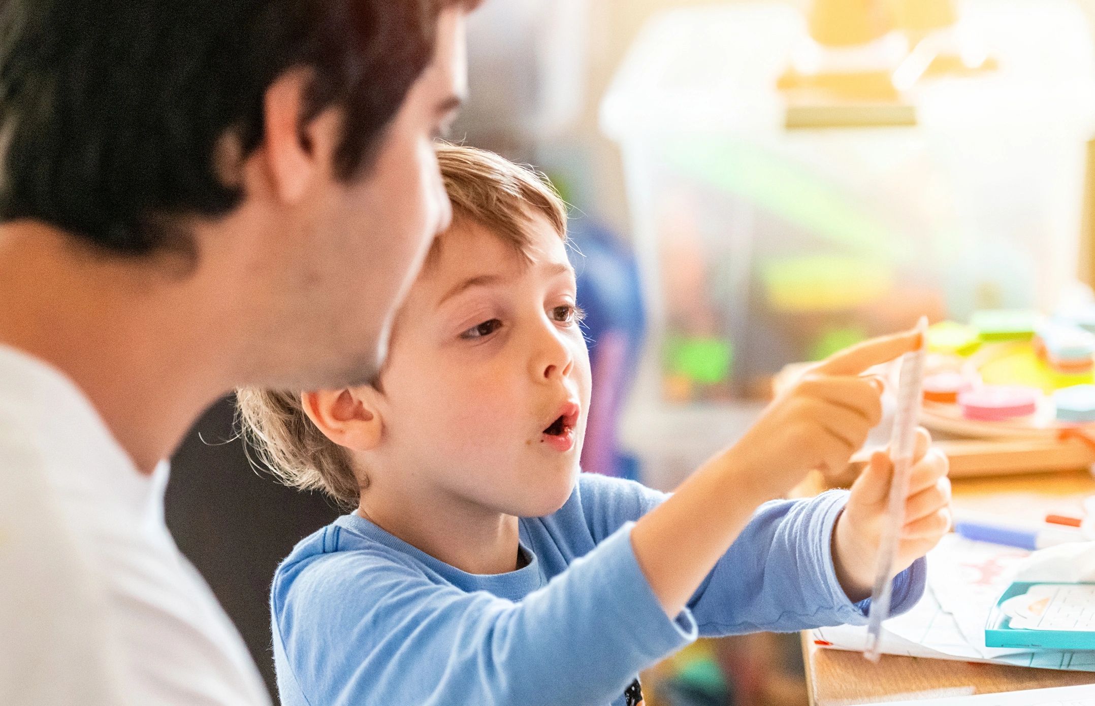Parent helping a child learn through play at home