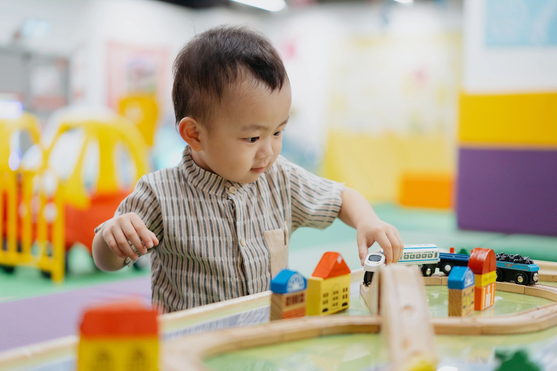 Toddler boy playing happily with toys indoors