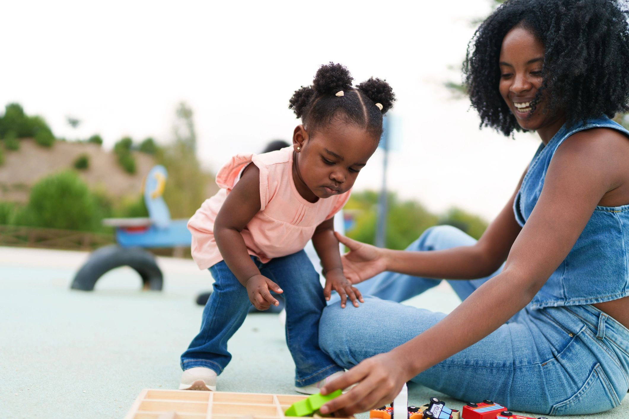 Mother and daughter playing together with toys